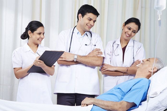 Medical team smiling at a patient in a hospital bed.